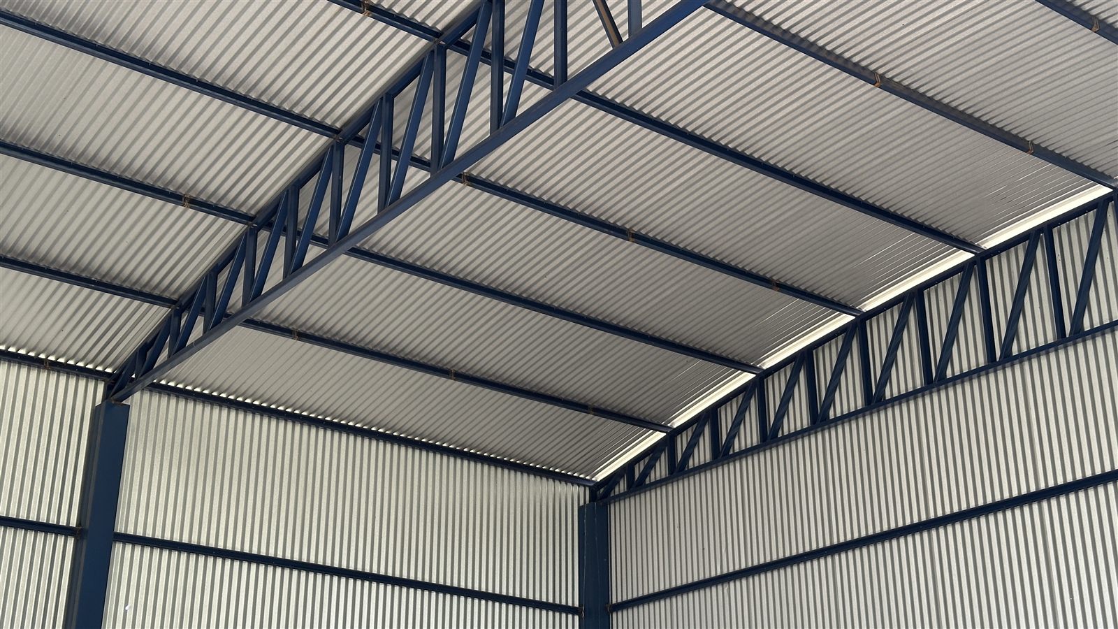 Detalhe da estrutura metálica e cobertura interna do galpão